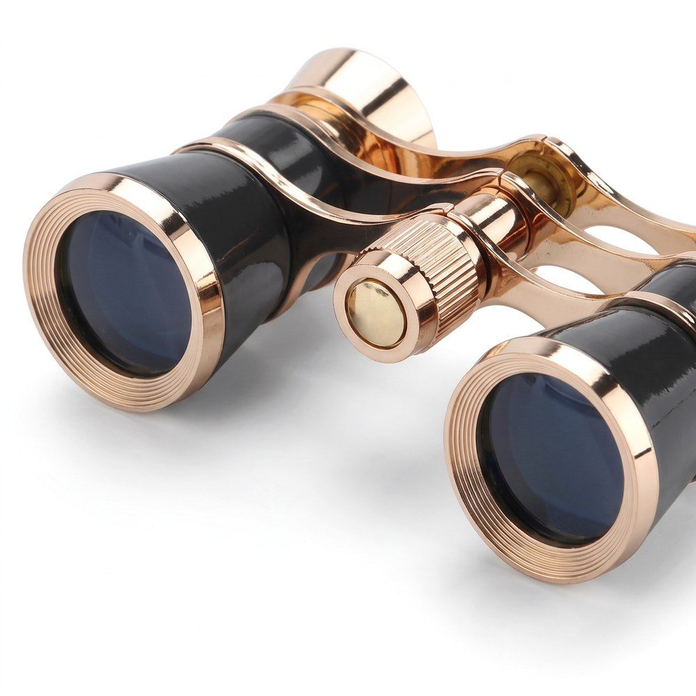 Gros plan sur les deux objectifs de 25 mm cerclés d'or des jumelles d'opéra